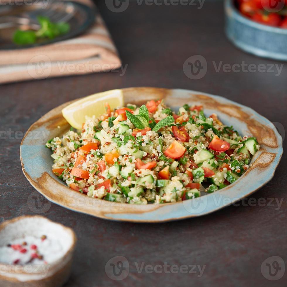 tabbouleh sallad med quinoa. österländsk mat med grönsaksmix, vegansk kost. sidovy, gammal tallrik foto