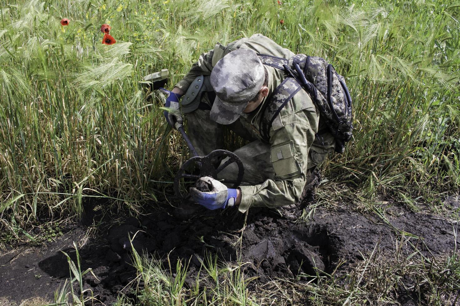 soldat som använder en metalldetektor i fält foto