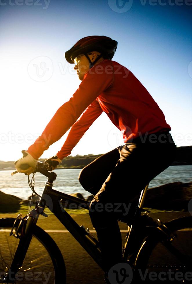 man cyklar under solnedgången foto
