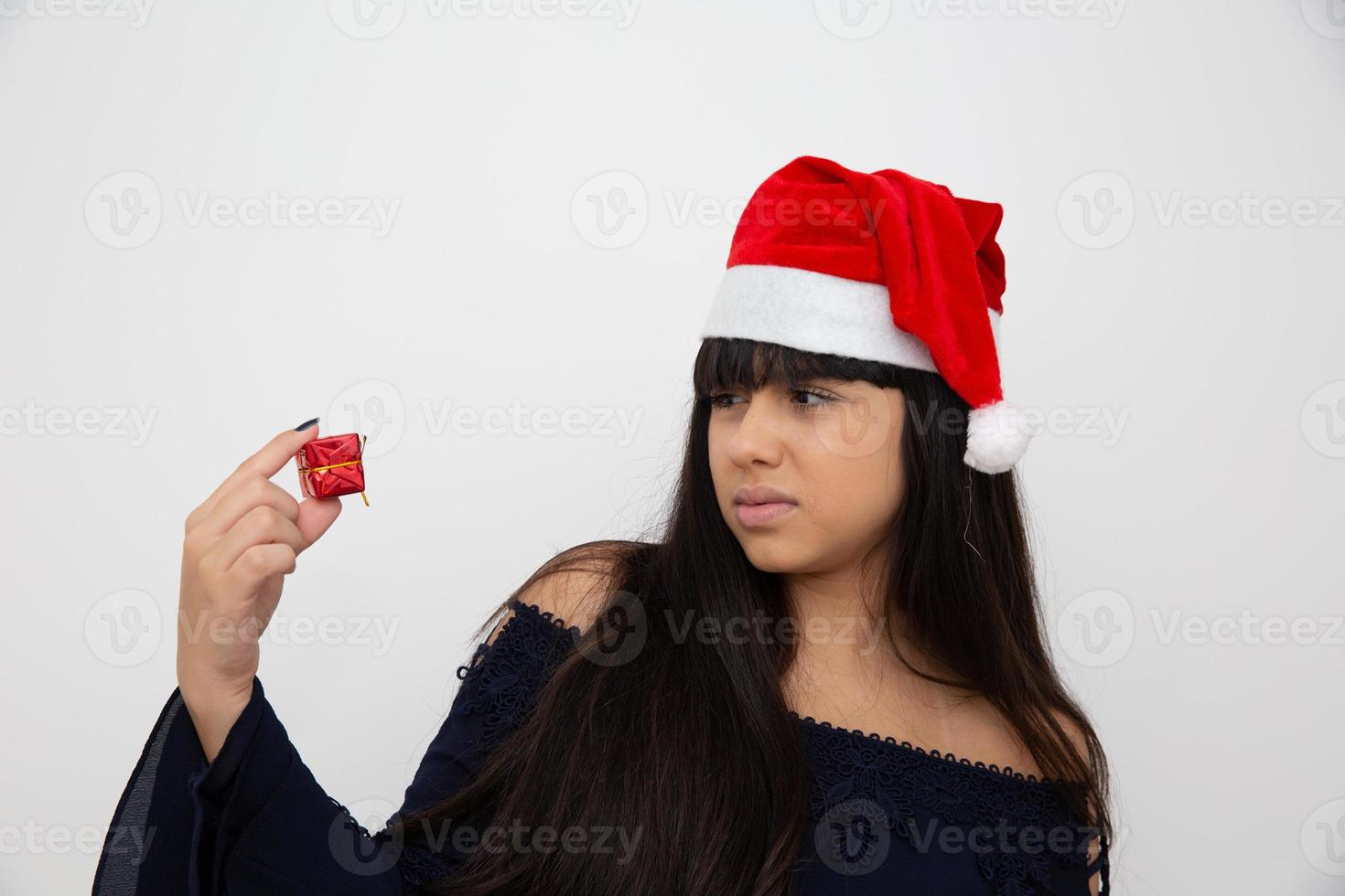 ung kvinna i santa mössa håller julklapp foto