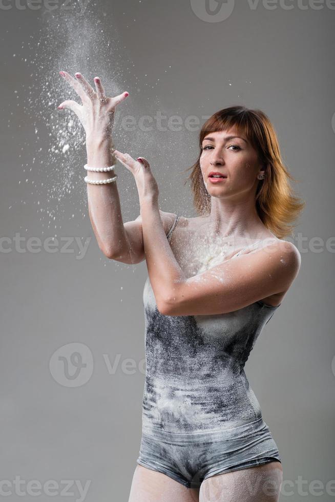 vacker uttrycksfull balettdansör som poserar med mjöl i studion foto