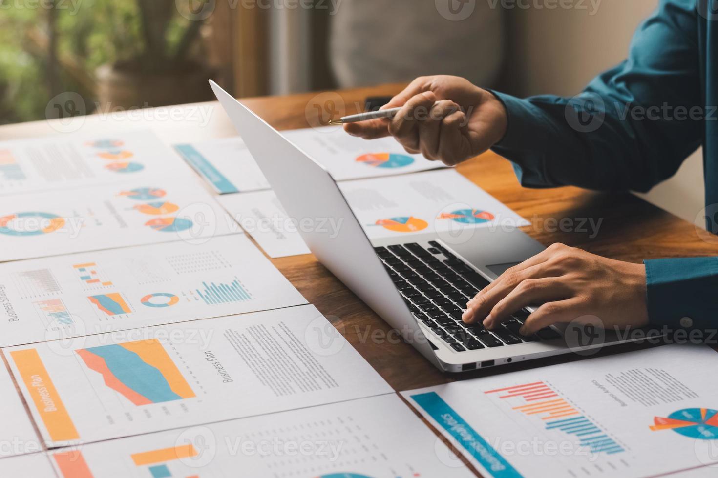 affärsman som arbetar på kontoret med dokument på sina skrivbord som planerar att analysera finansiella rapporter affärsplan investeringskoncept för finansiell analys. foto