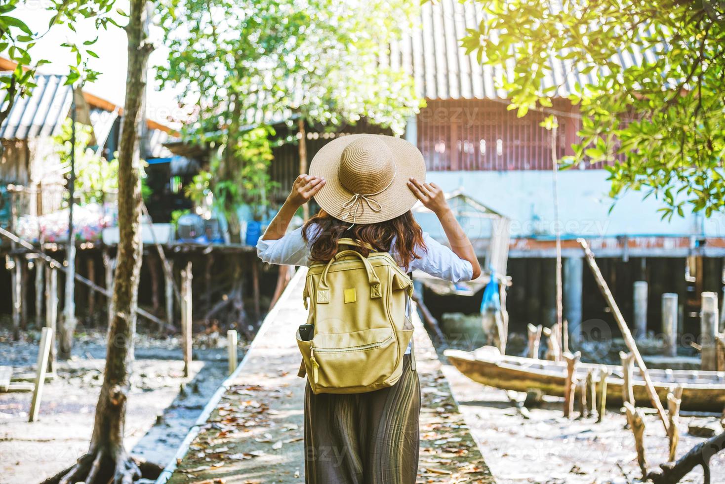 asiatisk kvinna reser naturen promenad och titta på livsstilen för byborna på landsbygden byar fiskare. turism, sommar, sjö, semester, resor thailand. ryggsäck, natur, resor, semester foto