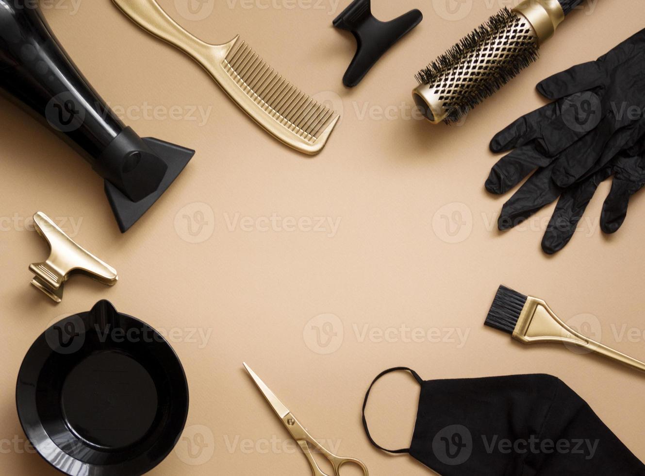 frisörverktyg på en beige bakgrund. ram av föremål frisörsalong, sax, handskar, mask, sax, kammar, hårtork. centrerat utrymme för text foto