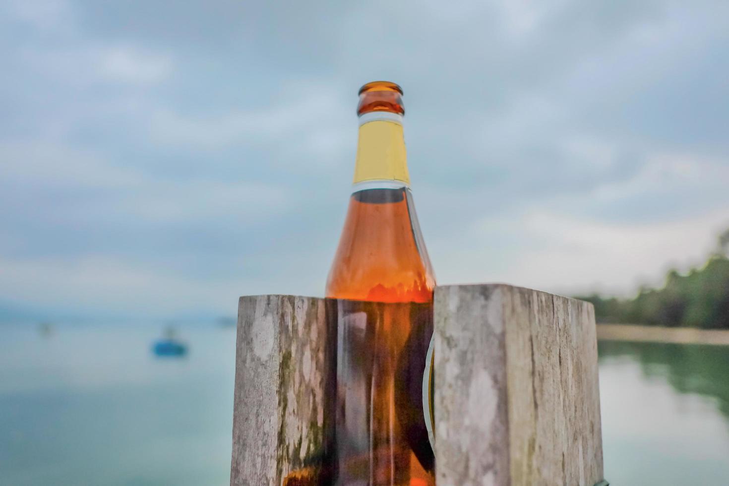 ölflaska på stranden efter festen.koh mak island trat thailand.sommar koncept foto