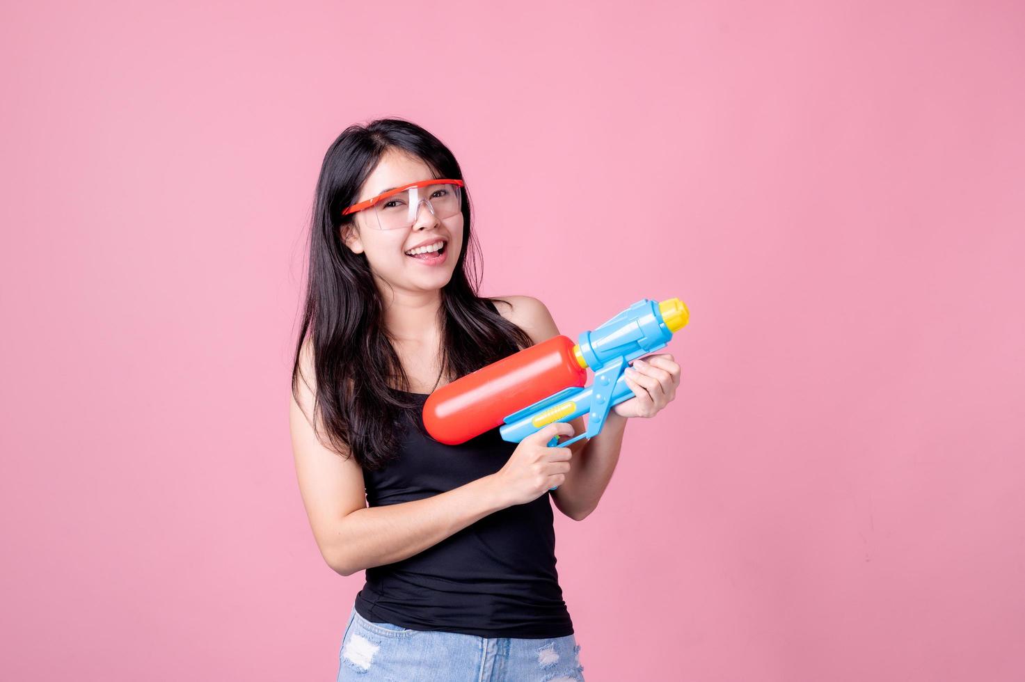 vackra asiatiska kvinnor håller plastvattenpistoler vid ett gammalt tempel under songkran, den vackraste och roligaste vattenfestivalen i thailand foto