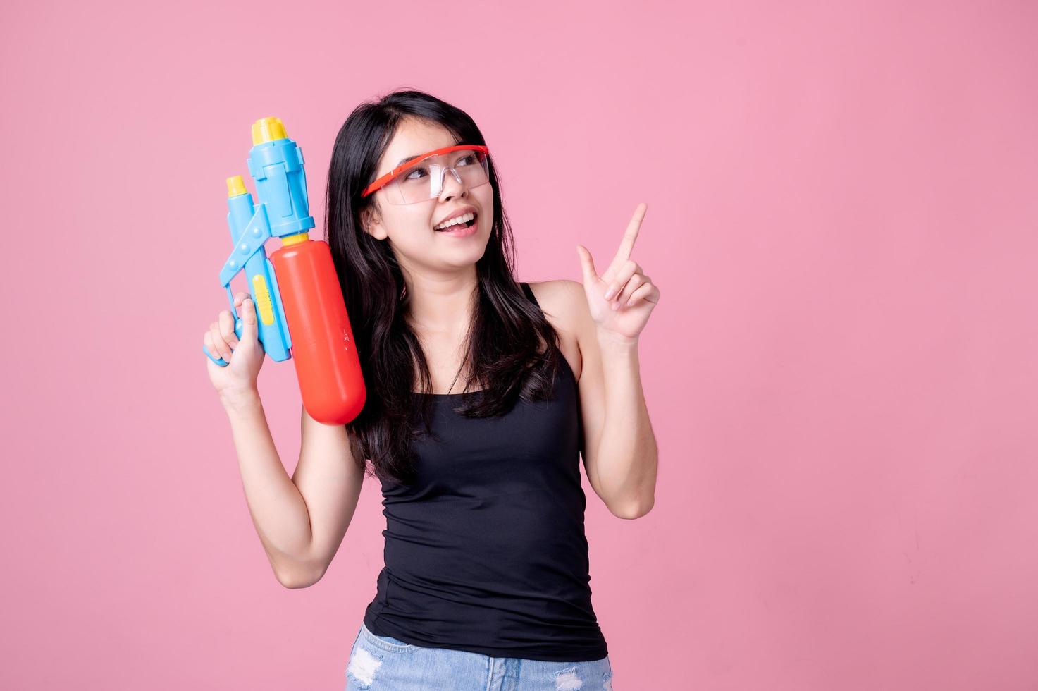 vackra asiatiska kvinnor håller plastvattenpistoler vid ett gammalt tempel under songkran, den vackraste och roligaste vattenfestivalen i thailand foto