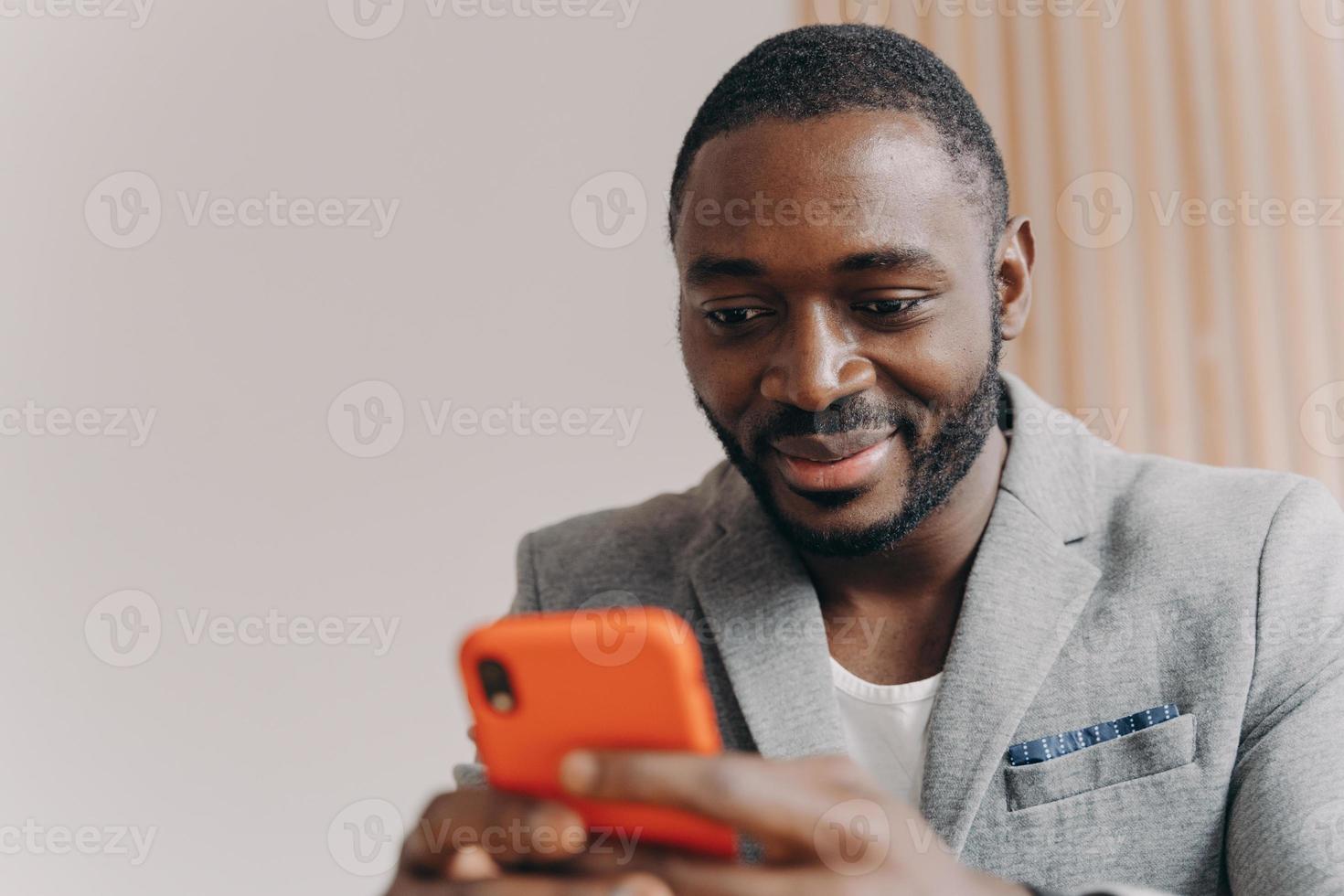 attraktiv självsäker ung afroamerikansk egenanställd som chattar med partners på smartphone foto