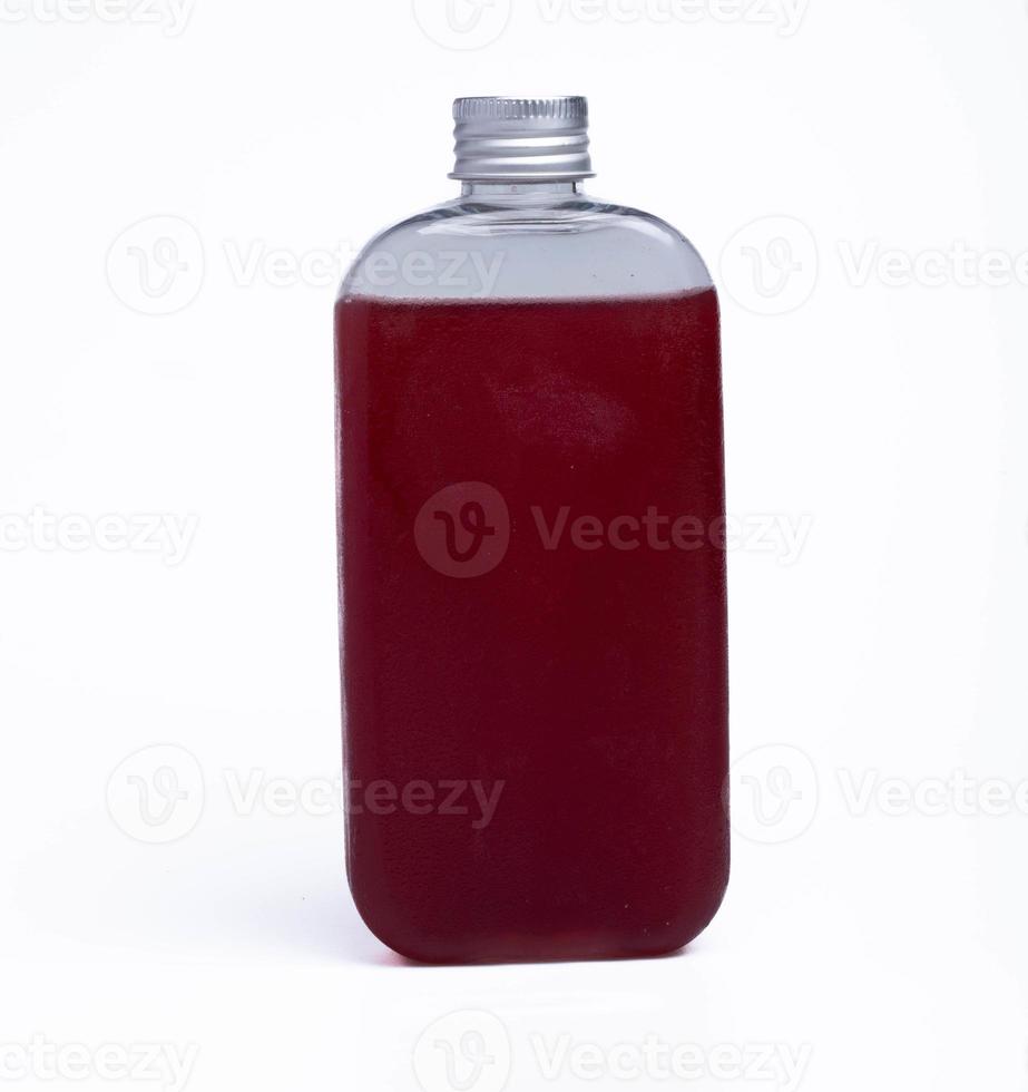 druvjuice i en klar flaska på en vit bakgrund foto