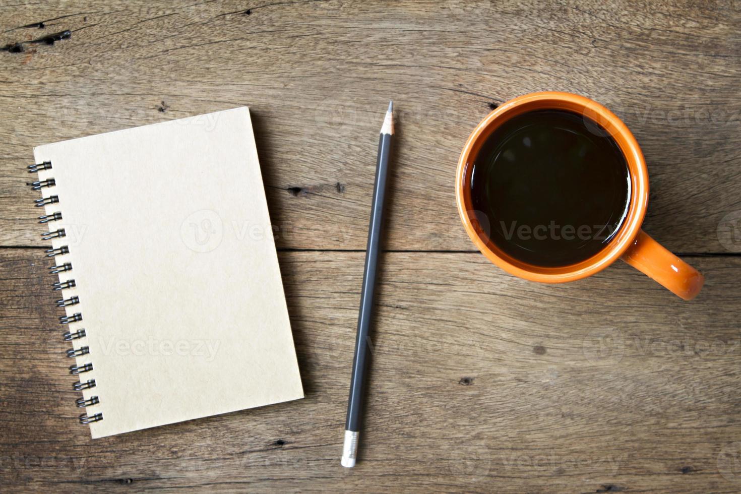 kaffe och anteckningsbok på träbakgrund foto