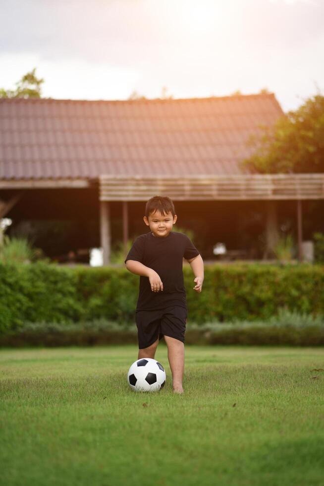 liten pojke som spelar fotboll fotboll foto