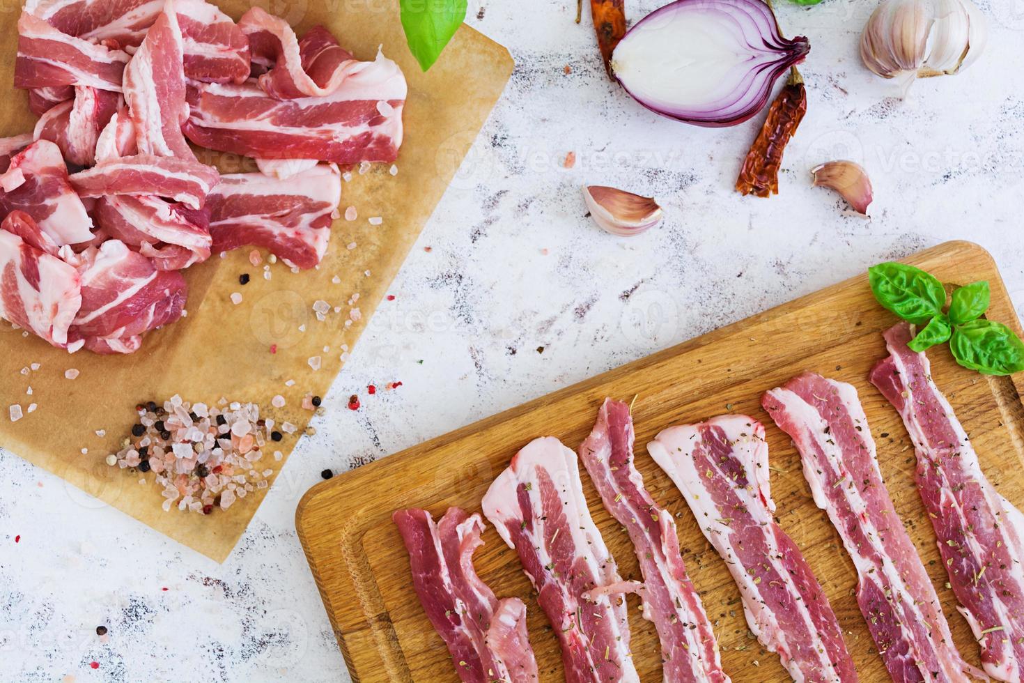 färsk skivad bacon med kryddor på vit bakgrund foto