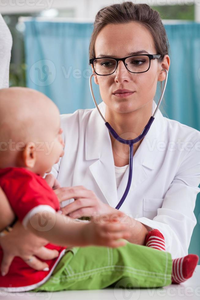 barns läkare auscultating baby foto