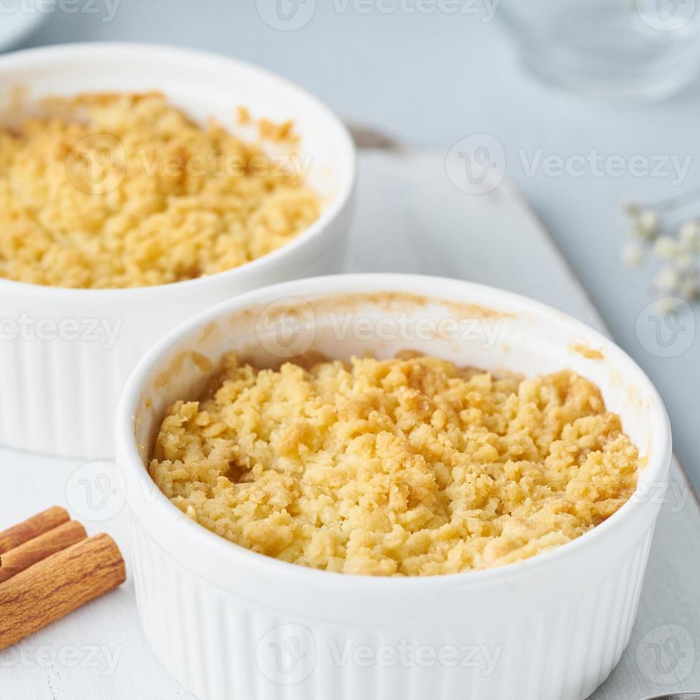 närbild äpple smula med streusel. sidovy. morgonfrukost på ljusgrått bord. foto