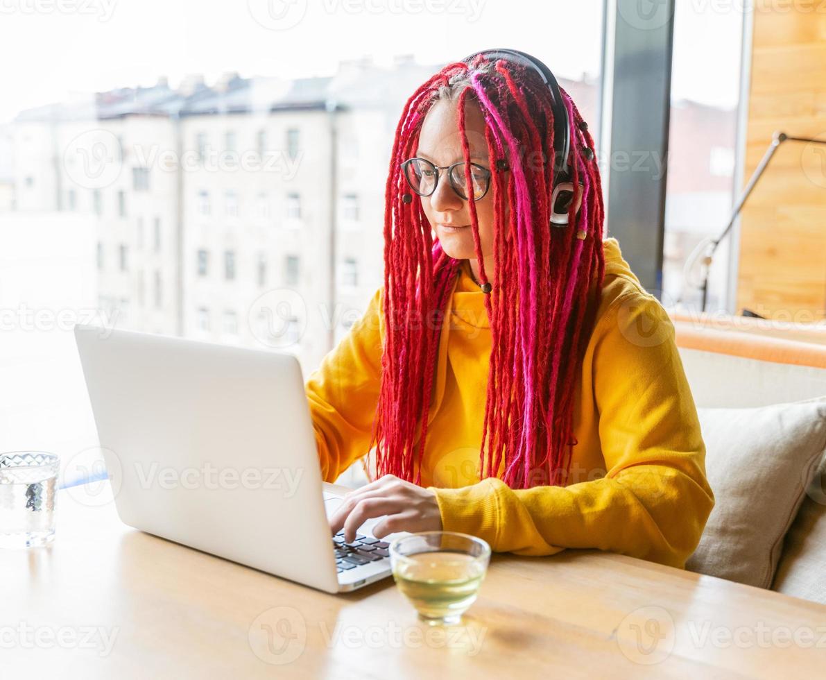 digital nomad koncept. flicka frilansare på distans arbetar på laptop i café, coworking. foto