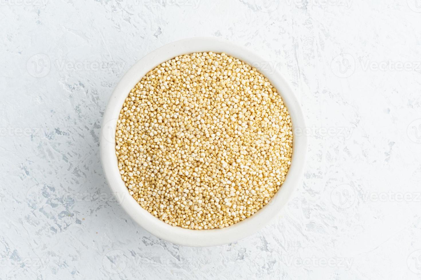 quinoafrö i vit skål på vit bakgrund. torkade spannmål i kopp, vegansk mat, fodmap-diet foto