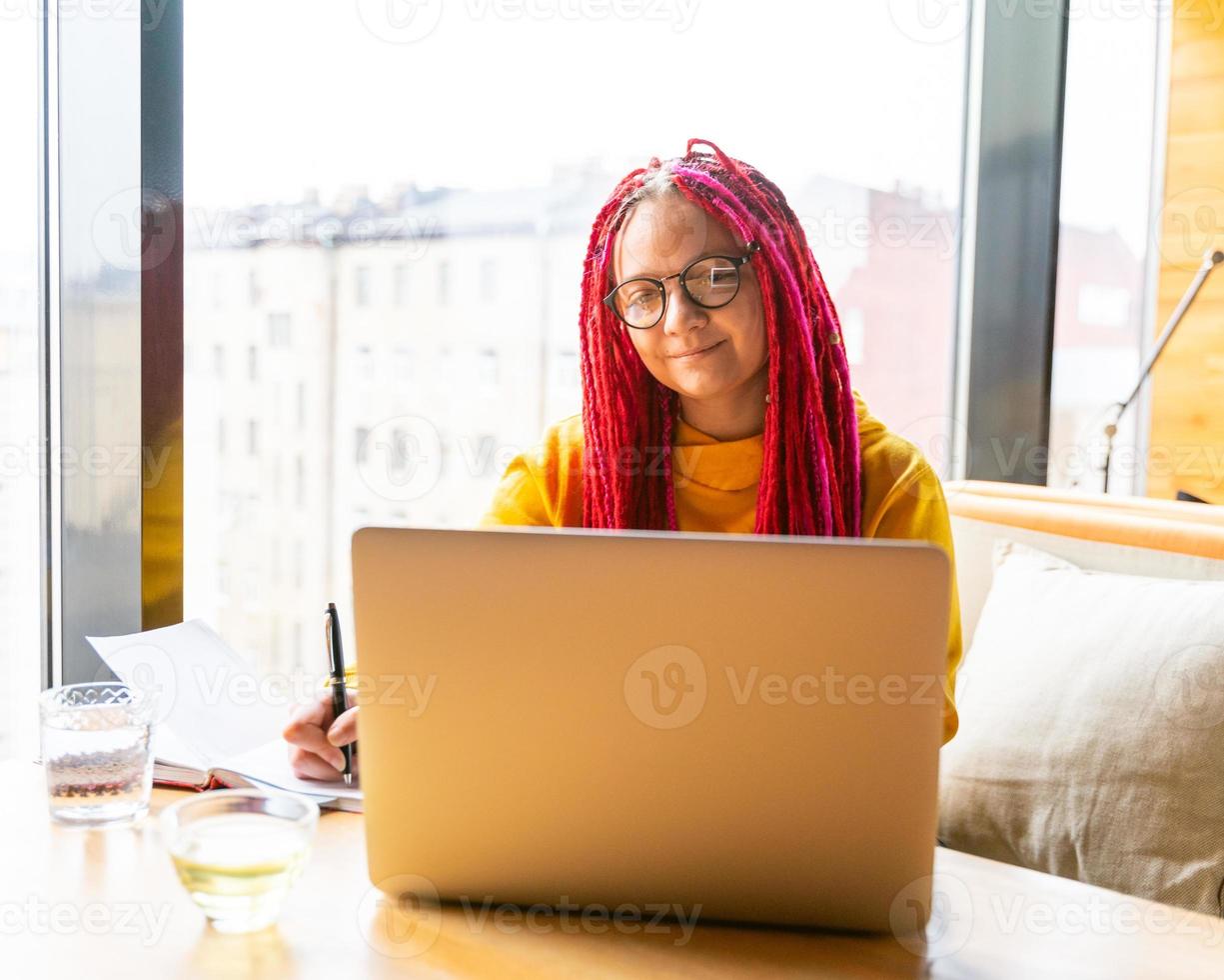 digital nomad koncept. flicka frilansare på distans arbetar på laptop i café, coworking. foto