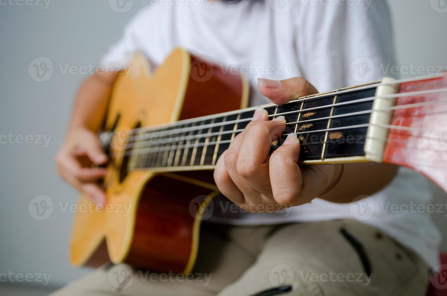 kvinnlig hand som spelar musik av akustisk gitarr foto