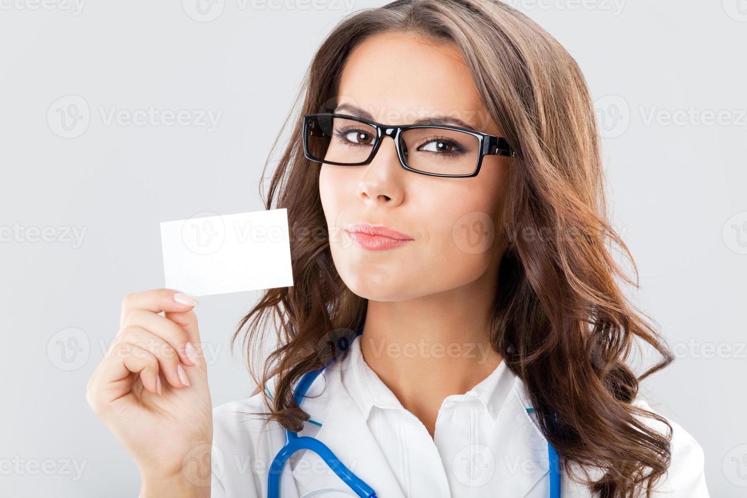 unga kvinnliga läkare visar tomma visitkort foto
