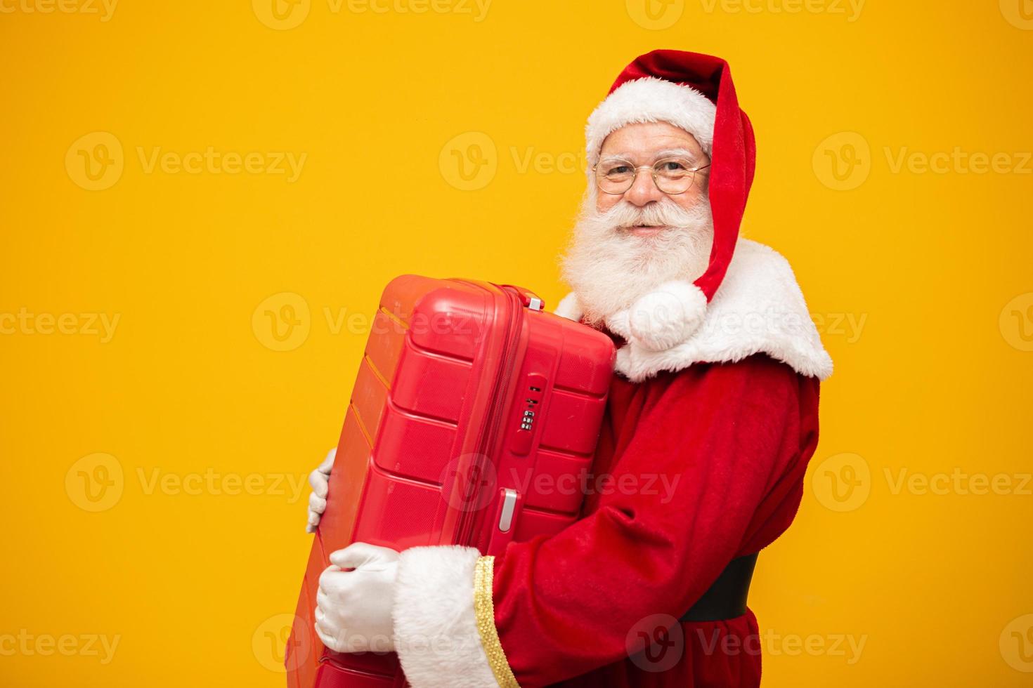 jultomten med sin resväska. nyårs resekoncept. jultomten på flygplatsen. foto
