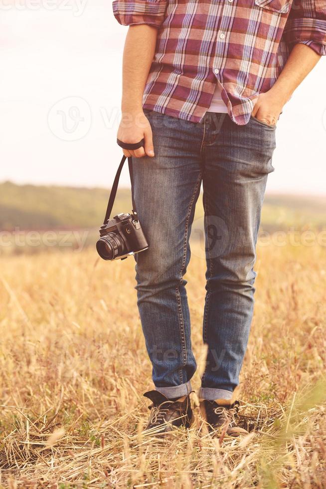 ung man med retro fotokamera utomhus hipster livsstil foto