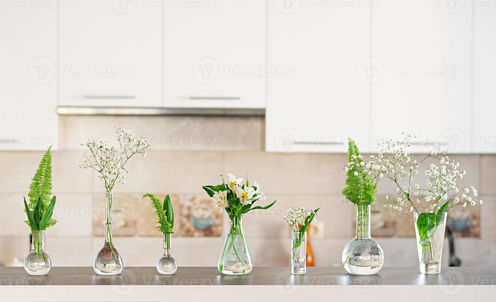 vackra vårblommor i vaser på ljus bakgrund foto