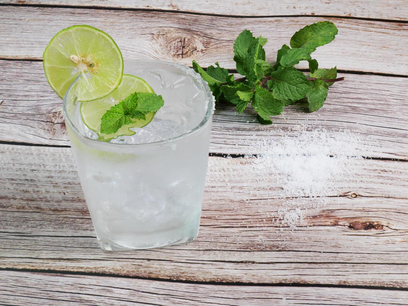 citronläsk kall dryck citronsaft med läsk på is garnerad med skivade citroner för att garnera. applicera citronsaft och salt i munnen på glaset. garnera med myntablad ovanför. som en drink foto