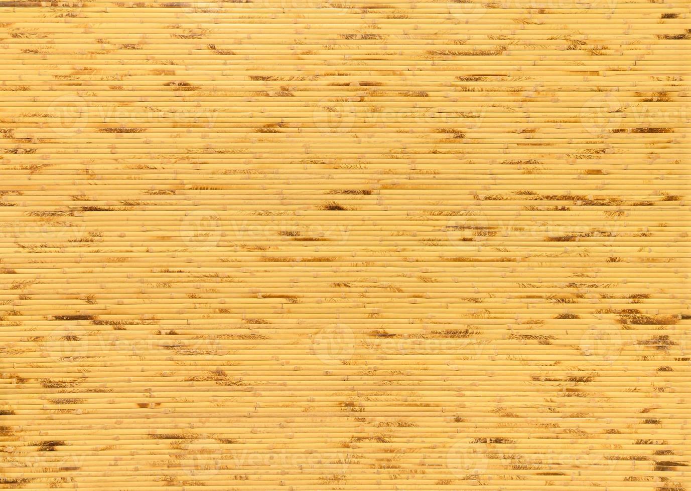 bakgrund och textur av dekorativt gult bambuträ på efterbehandling väggyta. bambu linje gör från eld bränna. foto