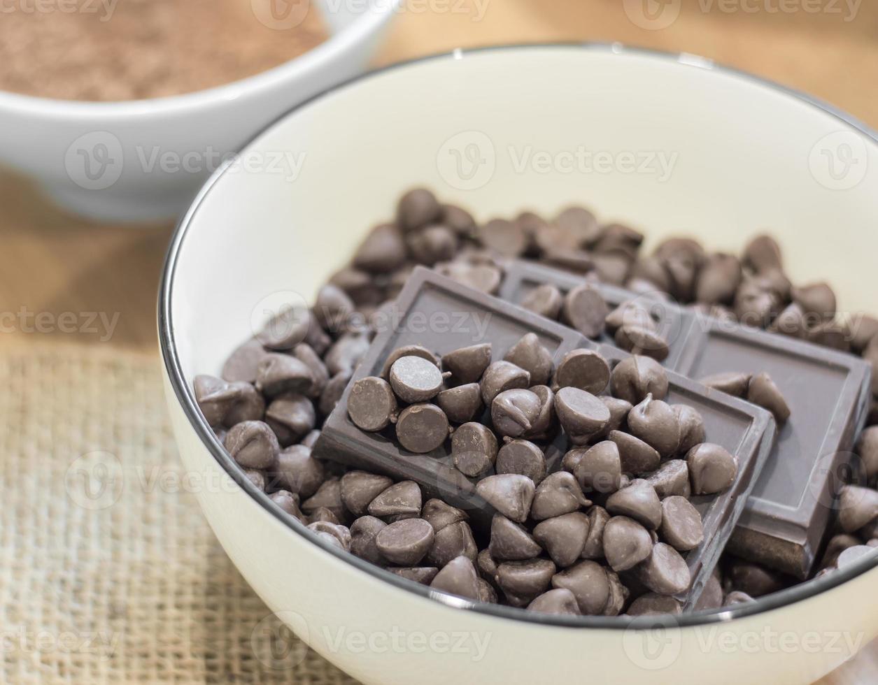 chokladchips och mörk chokladstång i vit skål. foto