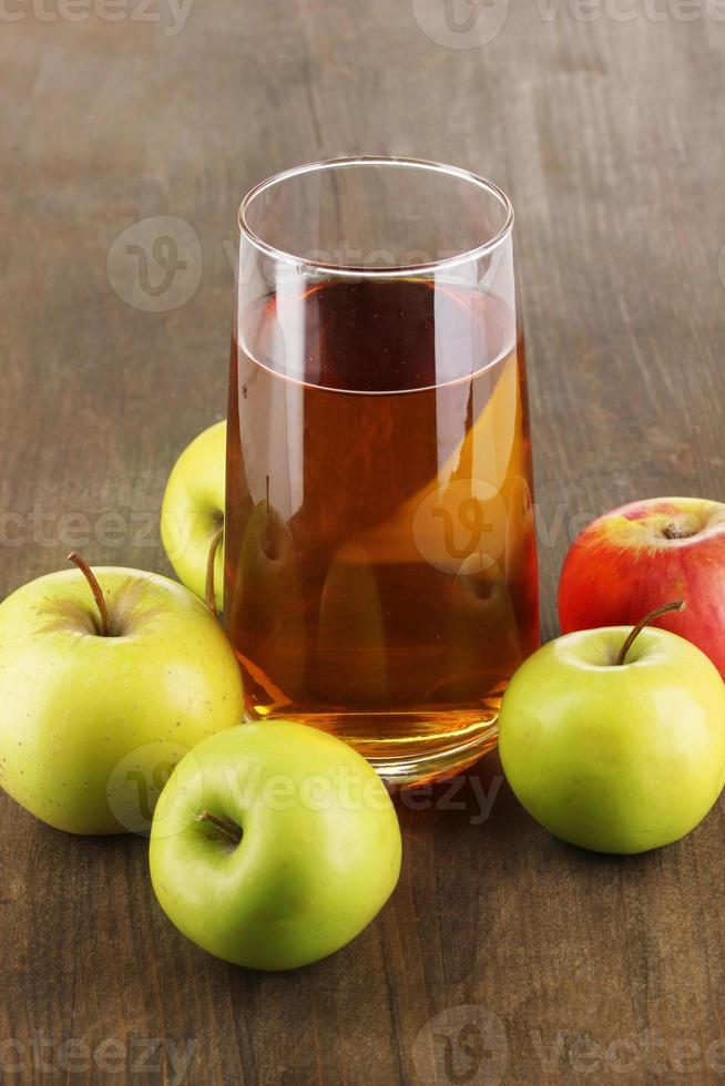 användbar äppeljuice med äpplen runt på träbord foto