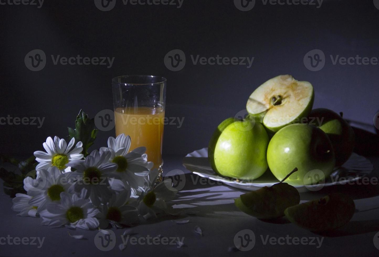 stilleben med prästkragar och äpplen. foto