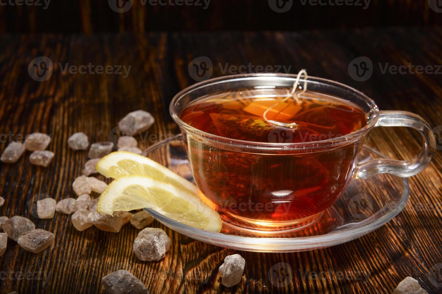 kopp te med citron på träbakgrund foto