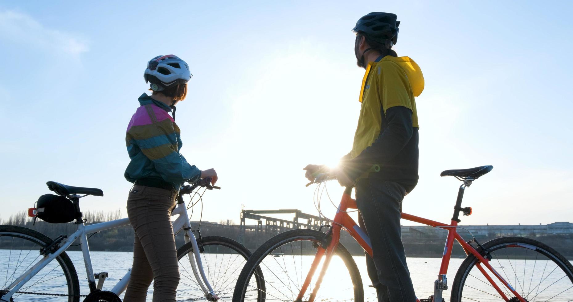 par män och kvinnor rida på cyklar nära floden under solnedgången foto