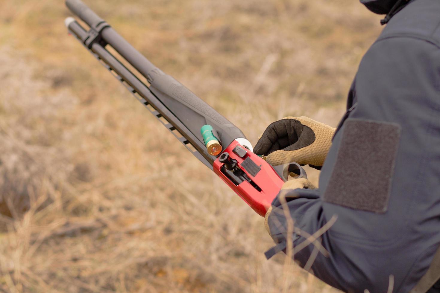 manlig utbildning med pump action hagelgevär utomhus i fält. foto