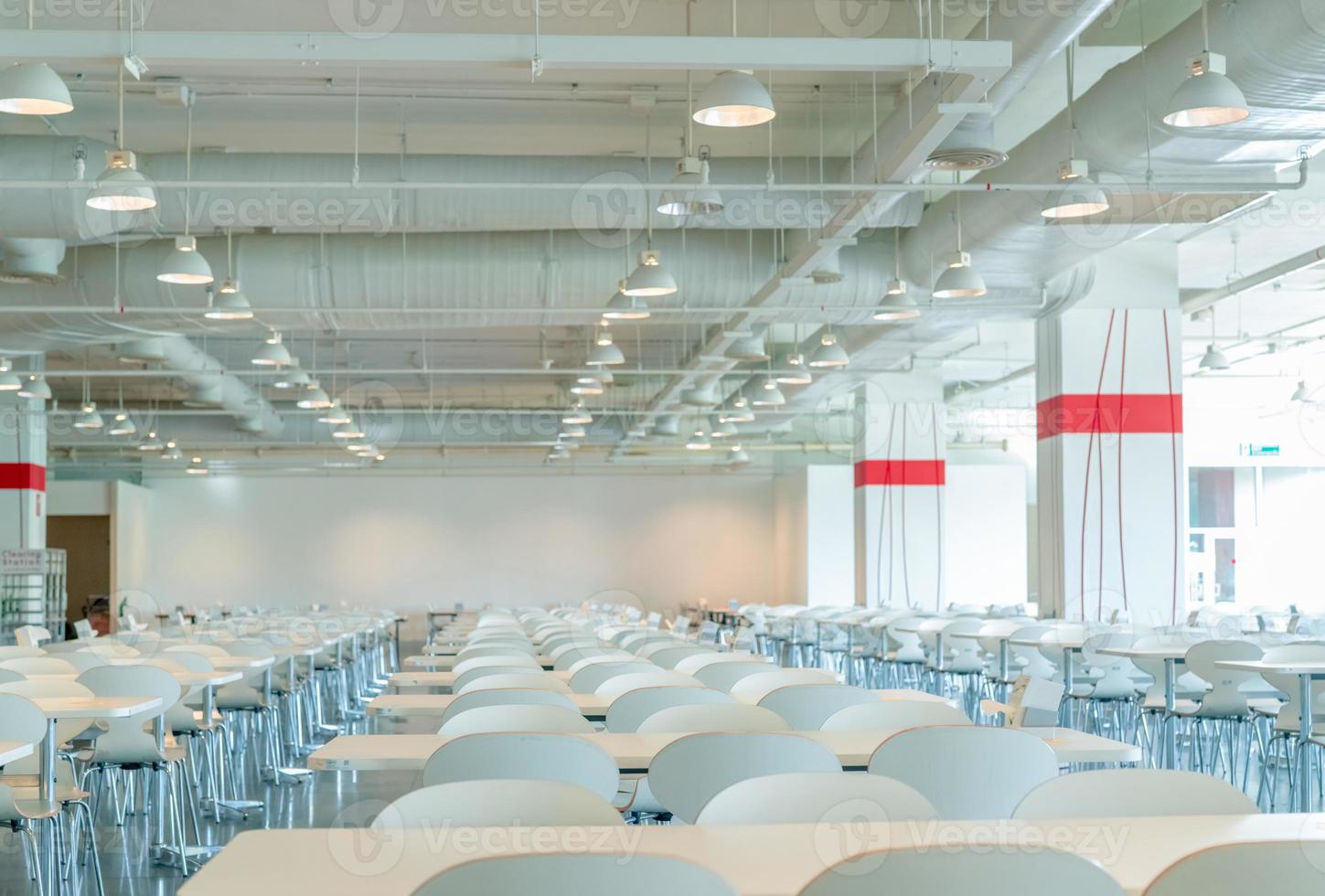 tom vit stol och bord i cafeterian i köpcentret. luftkanal, luftkonditioneringsrör och brandsprinklersystem. ventilationssystem. byggnadens interiör. taklampa ljus. inredningsarkitektur foto