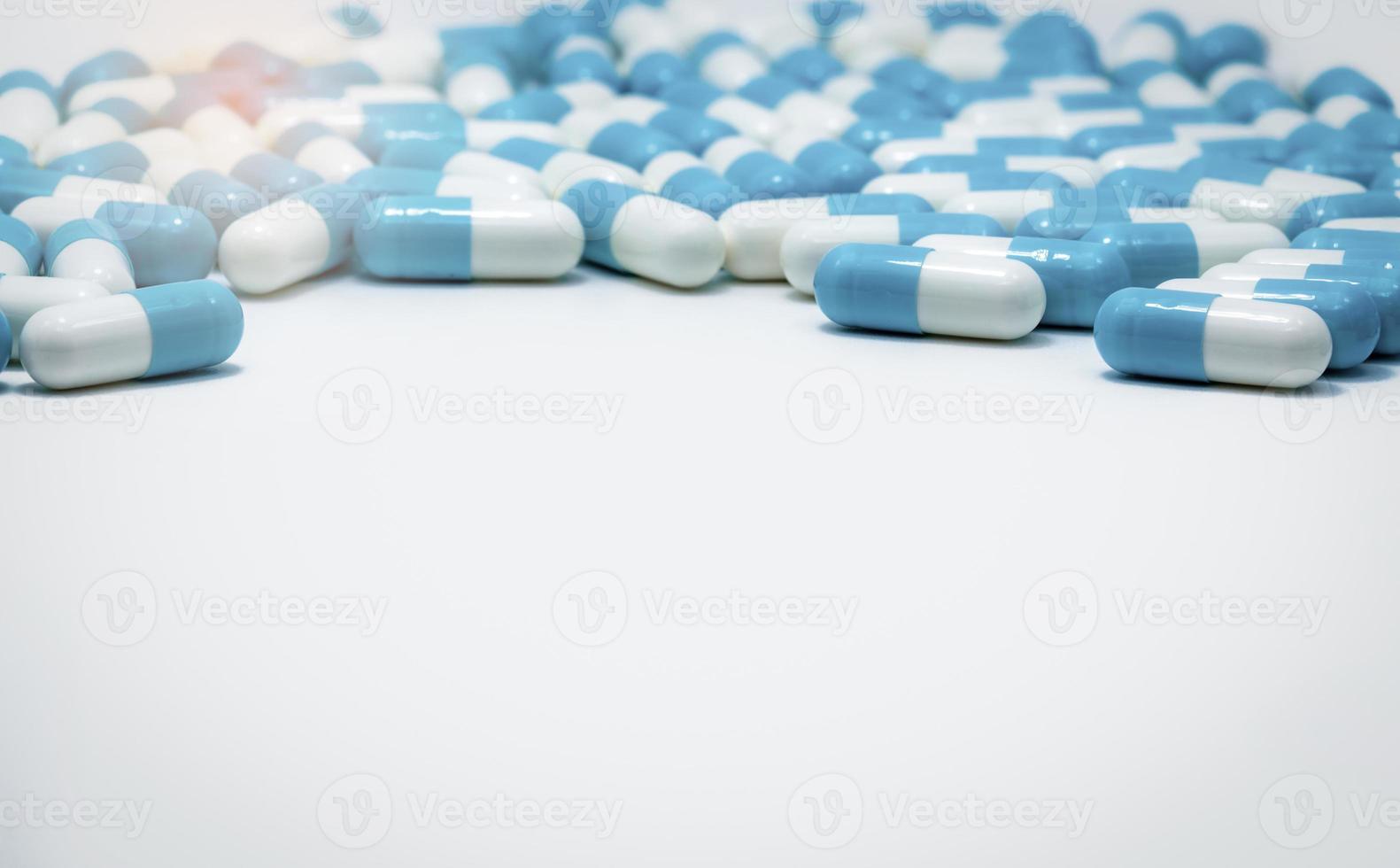 selektivt fokus på blå och vita kapslar piller på vit bakgrund. antibiotikaresistens. antimikrobiella kapselpiller. läkemedelsindustri. apoteksprodukter. farmaci. foto