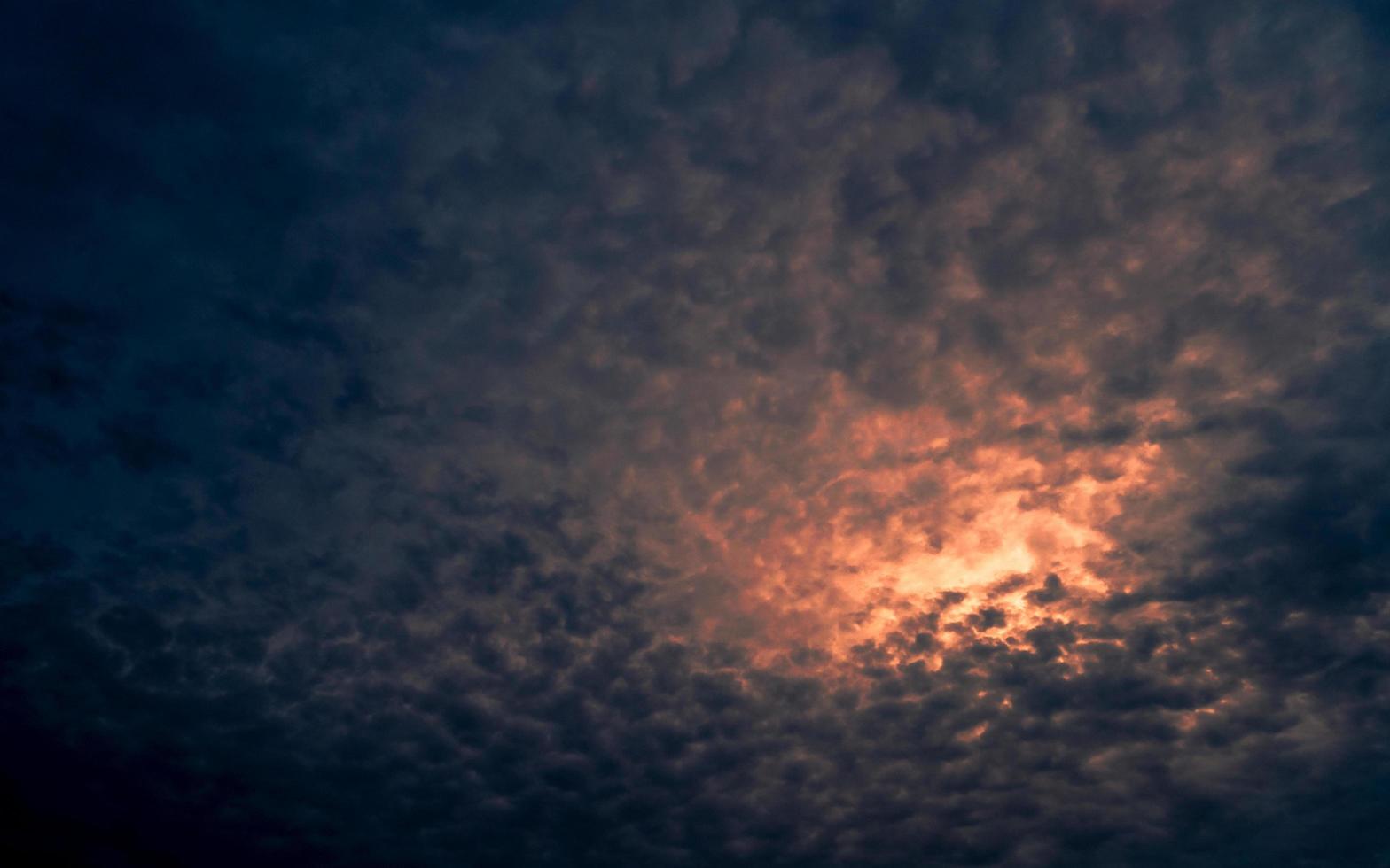 rött ljus av solen i mörkt molnig solnedgångshimmel. dramatisk himmel med vackra mönster av fluffiga moln. mental kraft eller psykisk kraftbakgrund. naturens kraft. exotiska molnlandskap. klimatförändringskoncept. foto