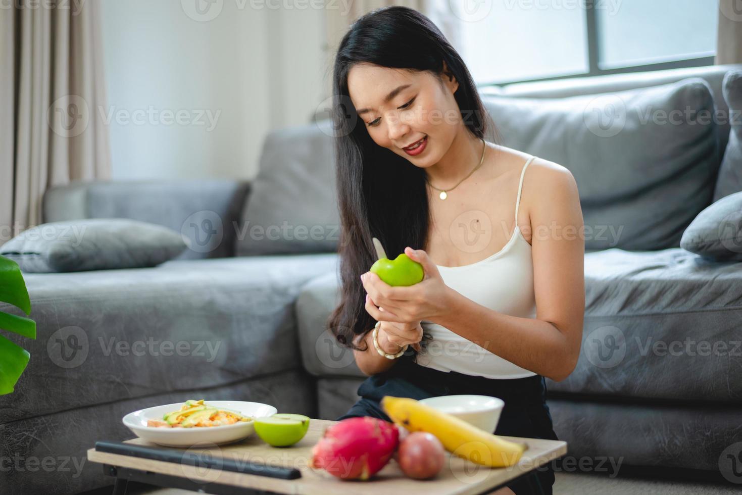 ung asiatisk kvinna flicka som håller hälsokost färsk grönsak i livsstil hemma, kvinnlig vacker vegetarian person som gör diet näring äter salladsmåltid, människor ler glada, hälsosam matkoncept foto