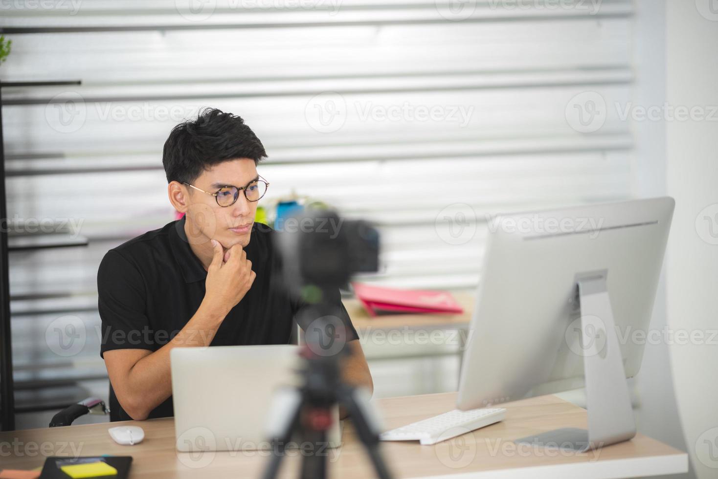 onlineförsäljning och marknadsföringskoncept för sociala medier, ung asiatisk man som arbetar med kamera till livestreaming för att sälja en produkt och visa paket för att granska, sända cyberrymden och bloggbutik foto