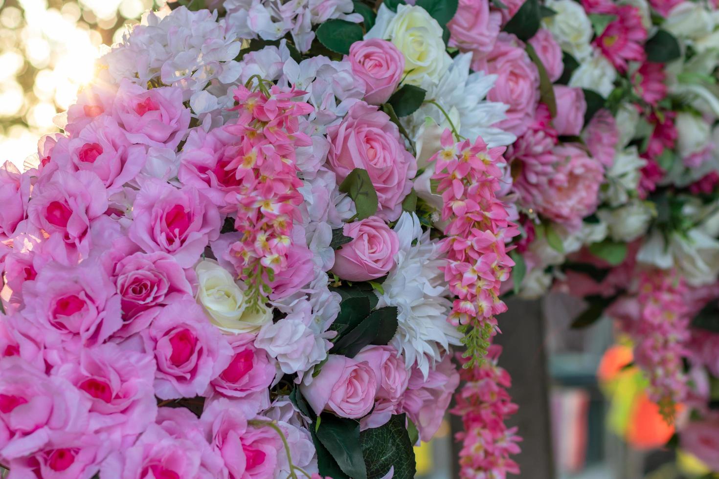 många konstgjorda buketter av rosa blommor med bokeh-belysning. foto