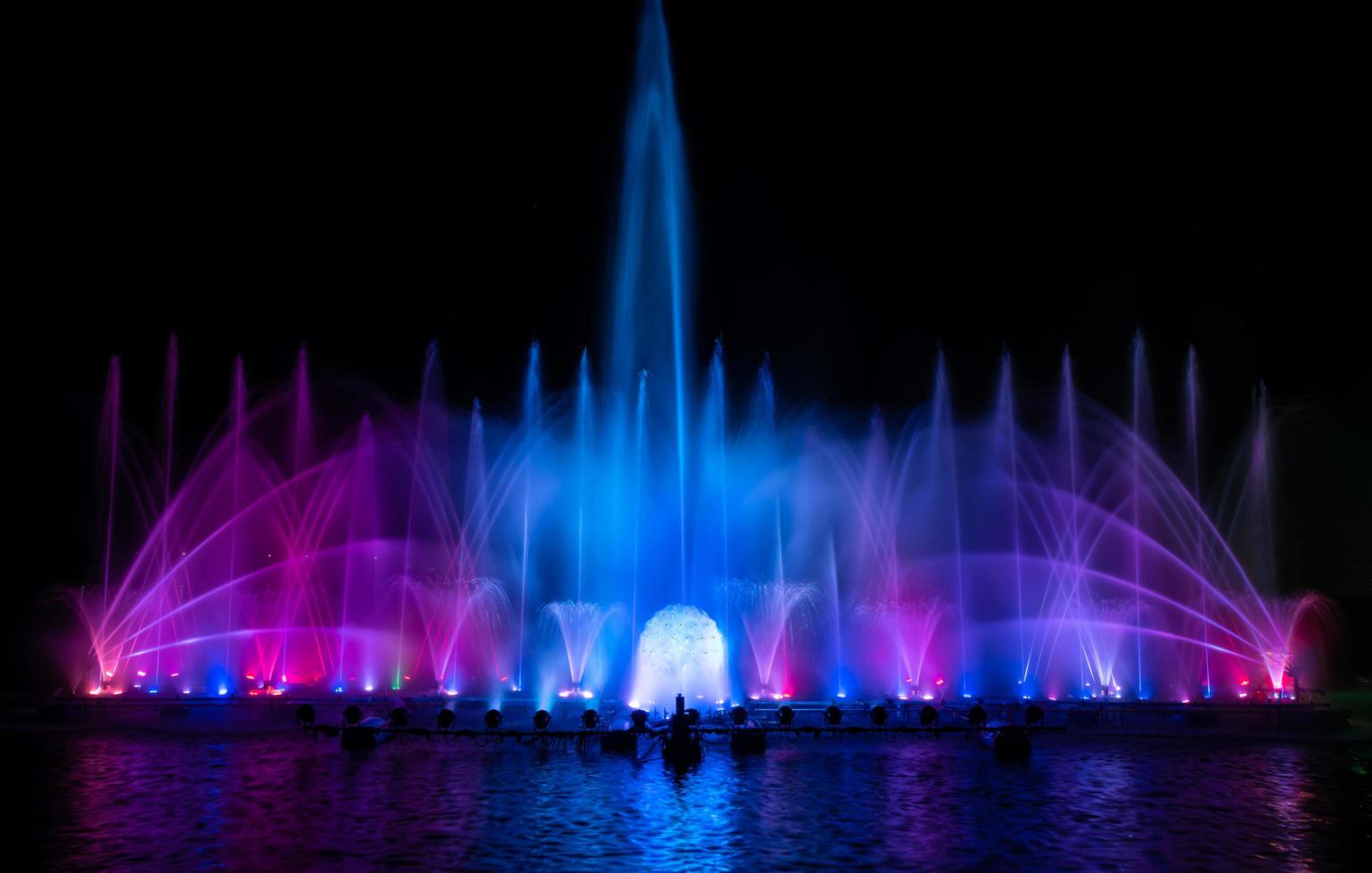 den färgglada fontänen dansar för att fira året med mörk natthimmelbakgrund. foto
