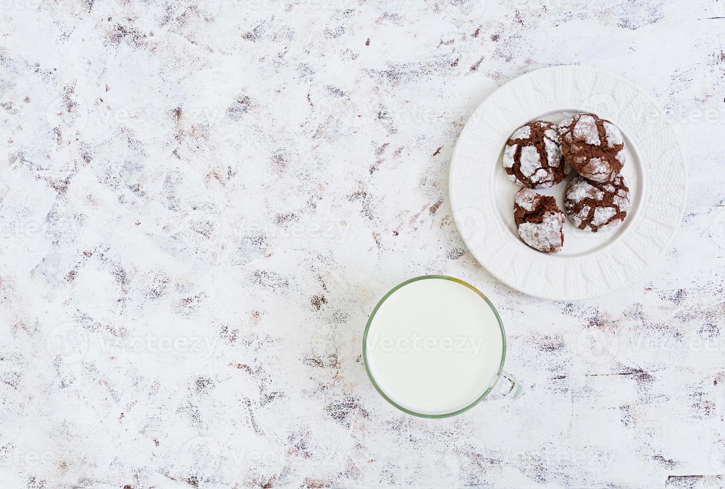 chokladkakor och ett glas mjölk på vit bakgrund. toppvy foto