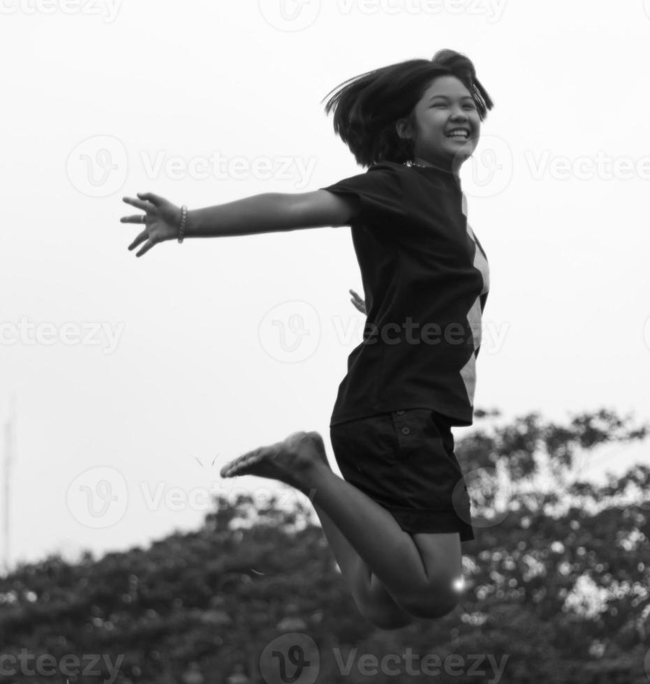 svart och vit tjej hoppar glatt. foto