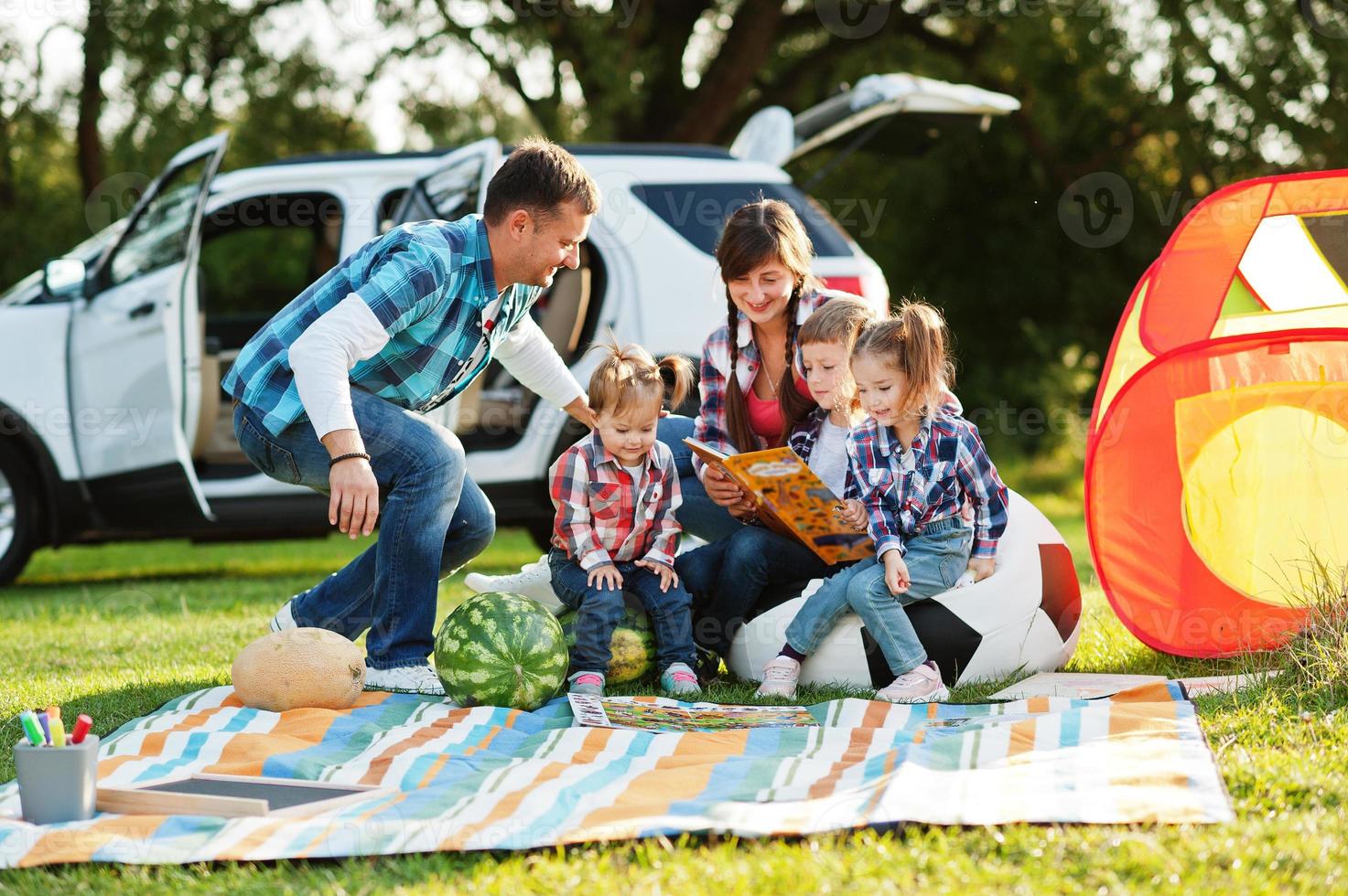 familjen spenderar tid tillsammans. tre barn. picknickfilt utomhus. foto