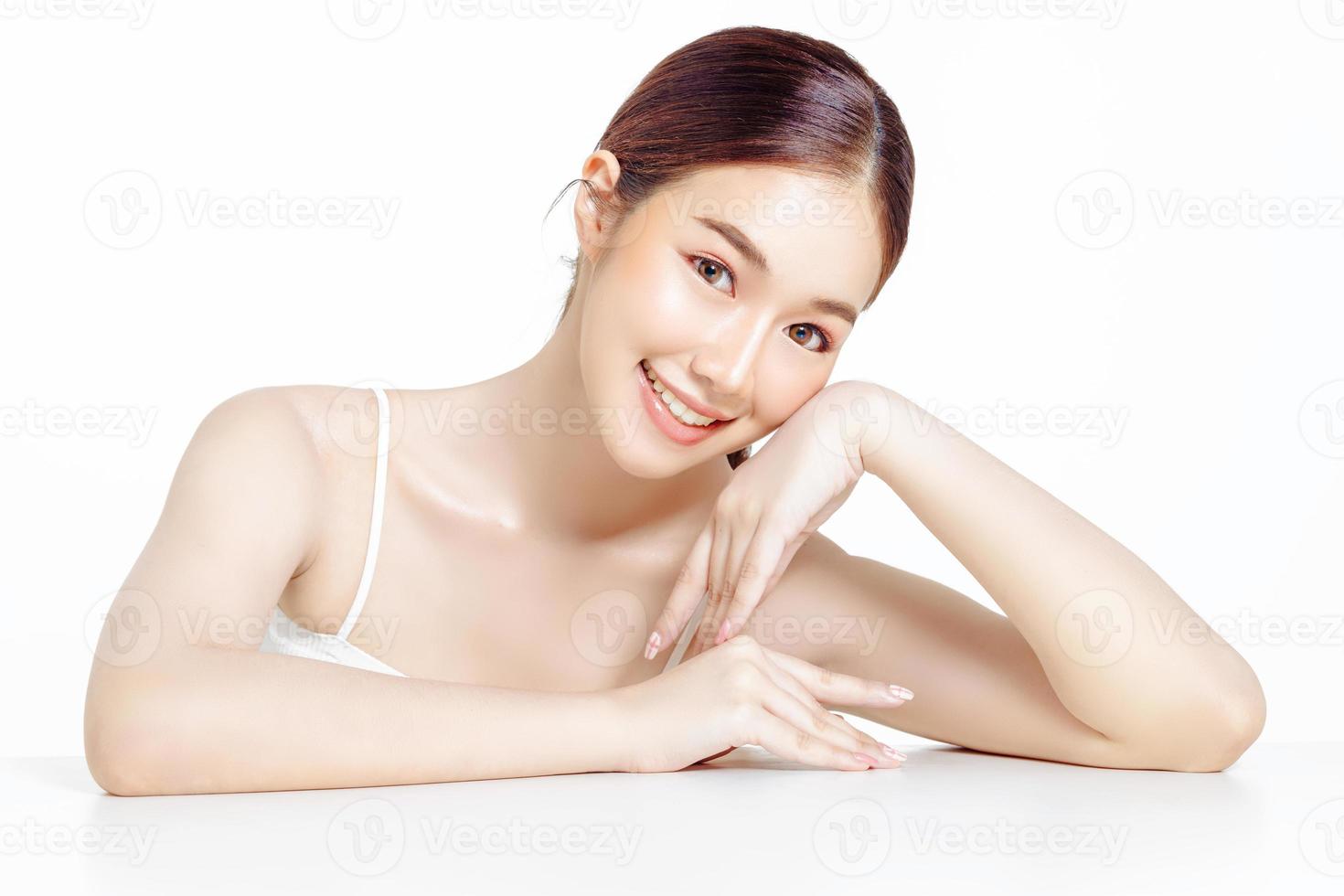 asiatisk kvinna med ett vackert ansikte samlat i en brun hästsvans och ren fräsch slät hud. foto