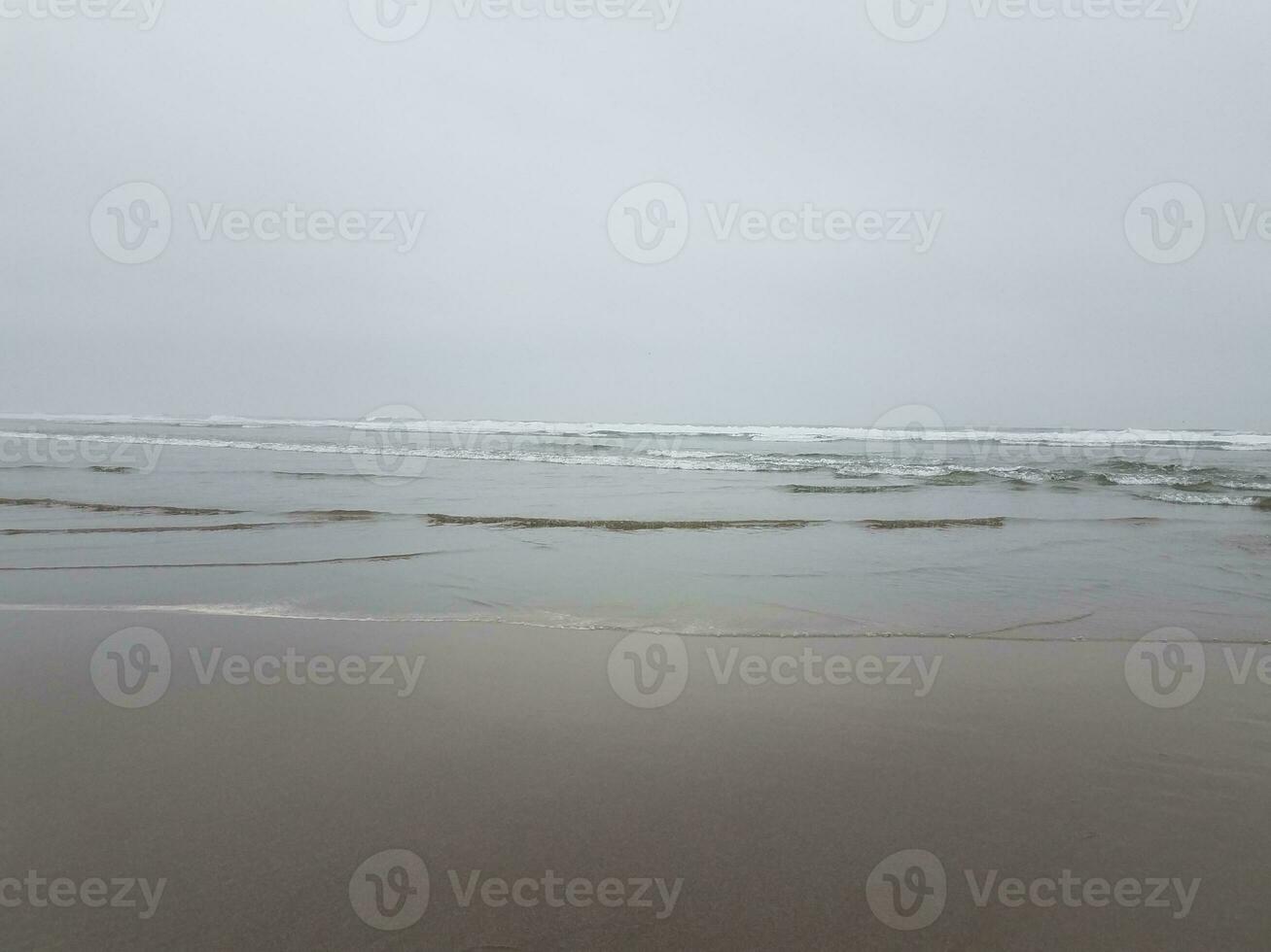 strand med våt sand, hav och vågor foto