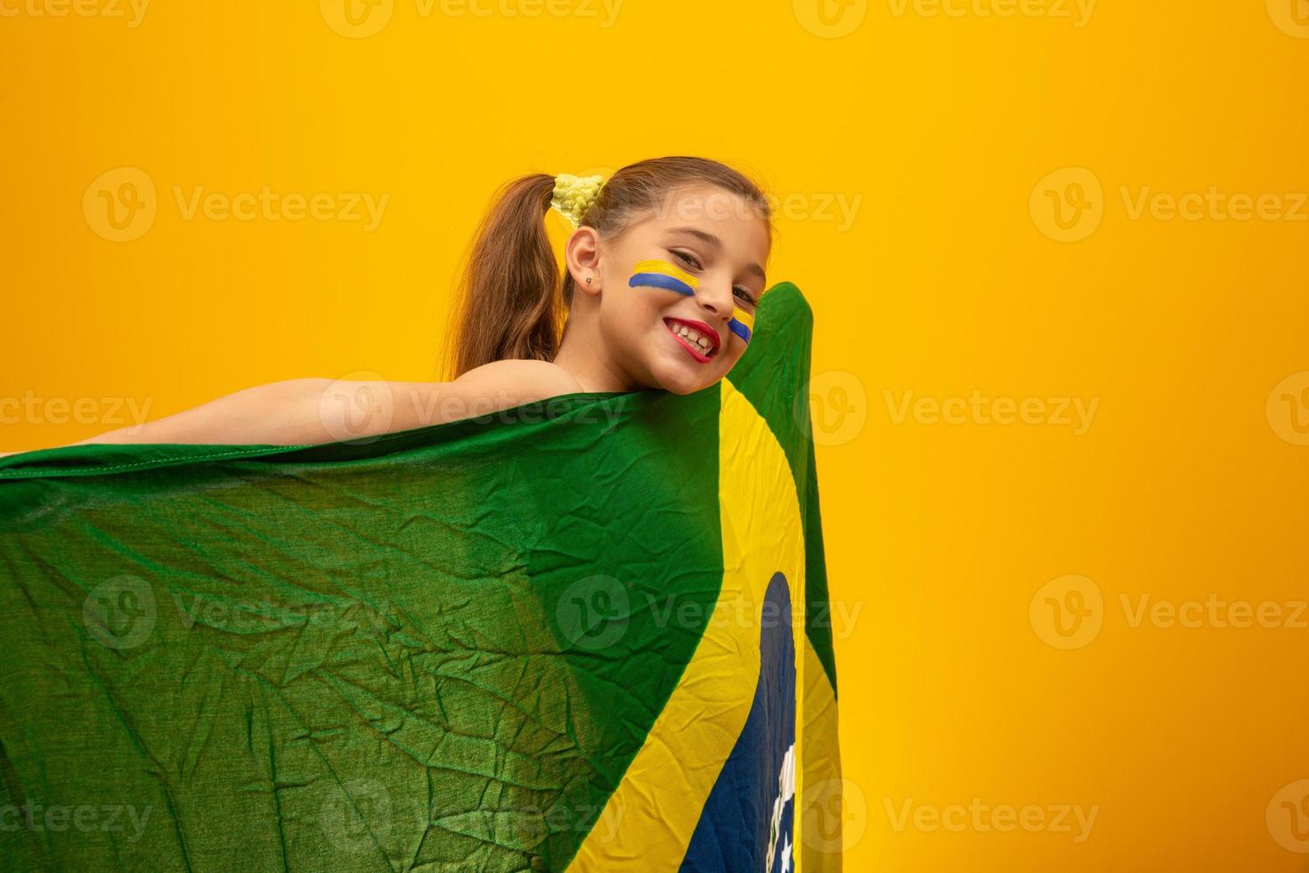 fotbollssupporter, brasiliens lag. världscupen. vacker liten flicka hejar på sitt team på gul bakgrund foto