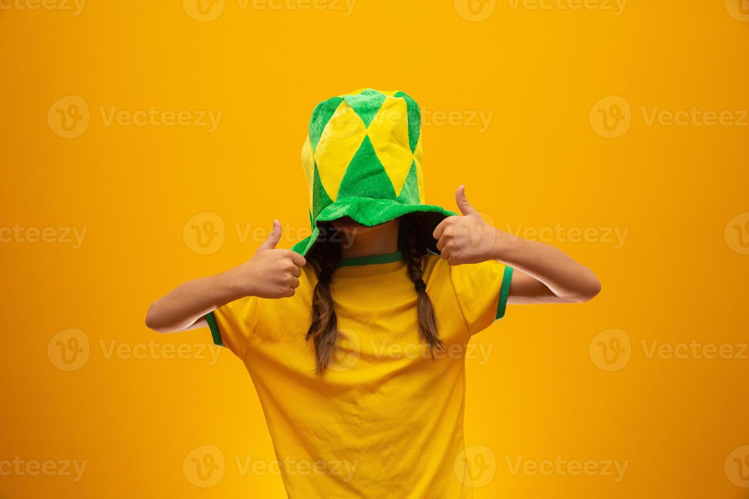 fotbollssupporter, brasiliens lag. världscupen. vacker liten flicka hejar på sitt team på gul bakgrund foto