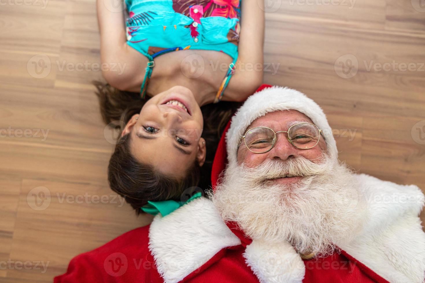 jultomten levererar en presentask till en liten flicka. julafton, leverans av presenter. foto