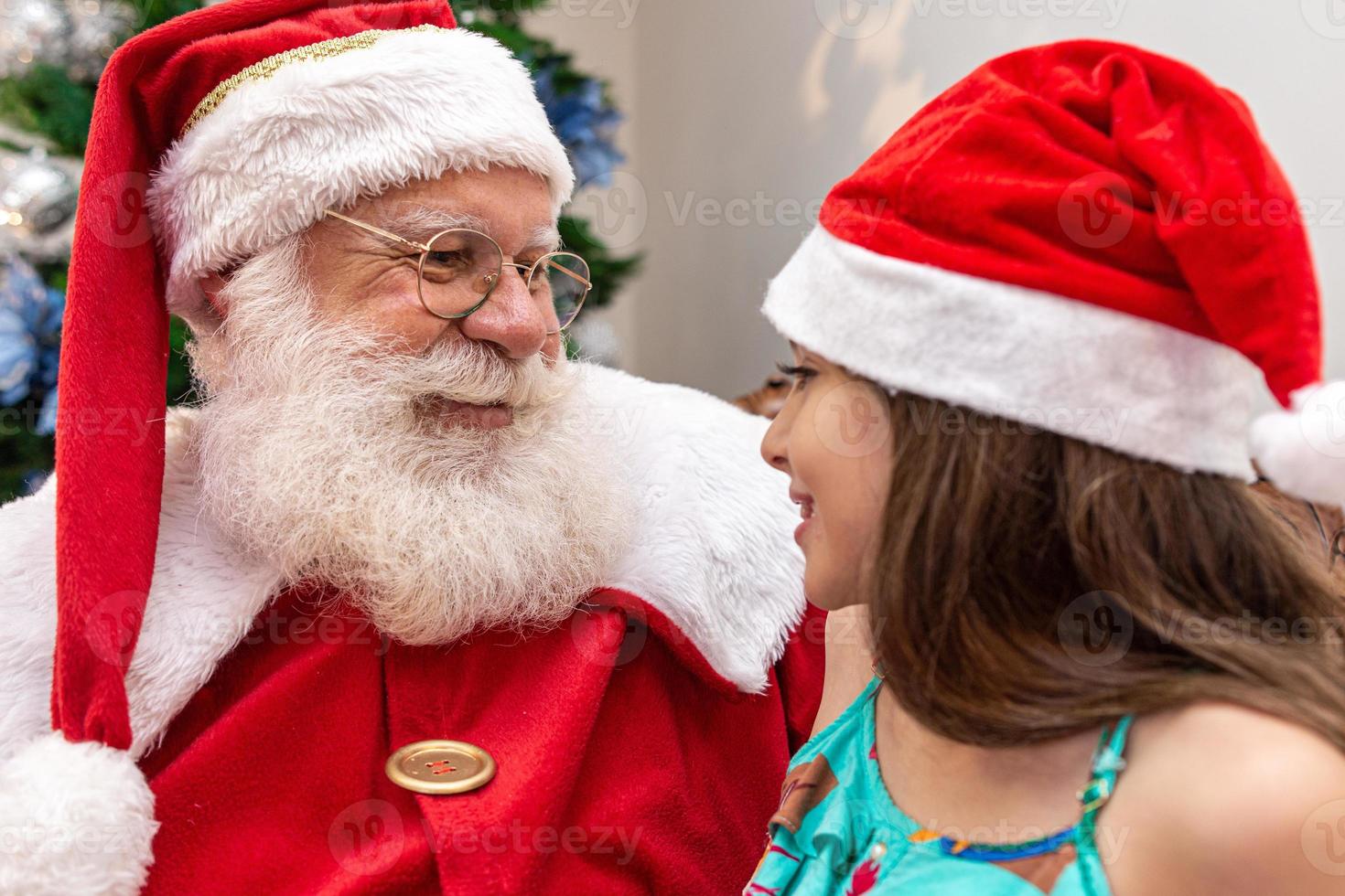 jultomten levererar en presentask till en liten flicka. julafton, leverans av presenter. foto